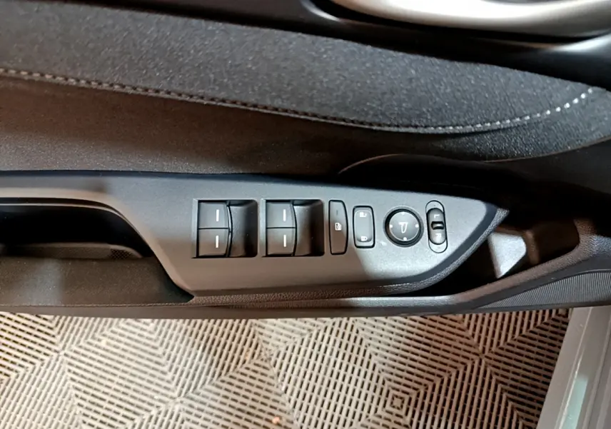 Gros plan sur les commandes de lève-vitres et rétroviseurs côté conducteur de la Honda Civic gris foncé 2020.