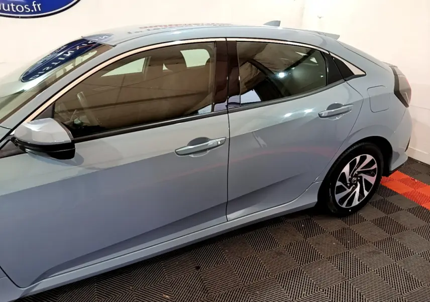 Vue latérale droite d'une Honda Civic gris foncé 2020, mettant en valeur les lignes épurées et les jantes stylisées.