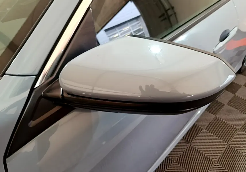 Gros plan sur le rétroviseur droit gris clair de la Honda Civic 1.0 i-VTEC Exclusive 2020, avec reflet lumineux.