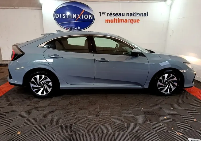 Vue latérale droite d'une Honda Civic 1.0 i-VTEC Exclusive gris foncé, avec jantes alliage et feux arrière distinctifs.