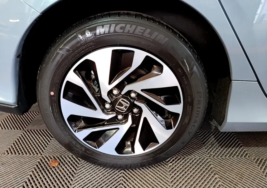 Gros plan sur la roue avant droite d'une Honda Civic 1.0 i-VTEC Exclusive gris foncé avec jante alliage et pneu Michelin.