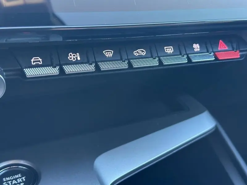 Gros plan sur la rangée de boutons de commande du tableau de bord du Peugeot 308 SW Rouge Elixir, version 2024.
