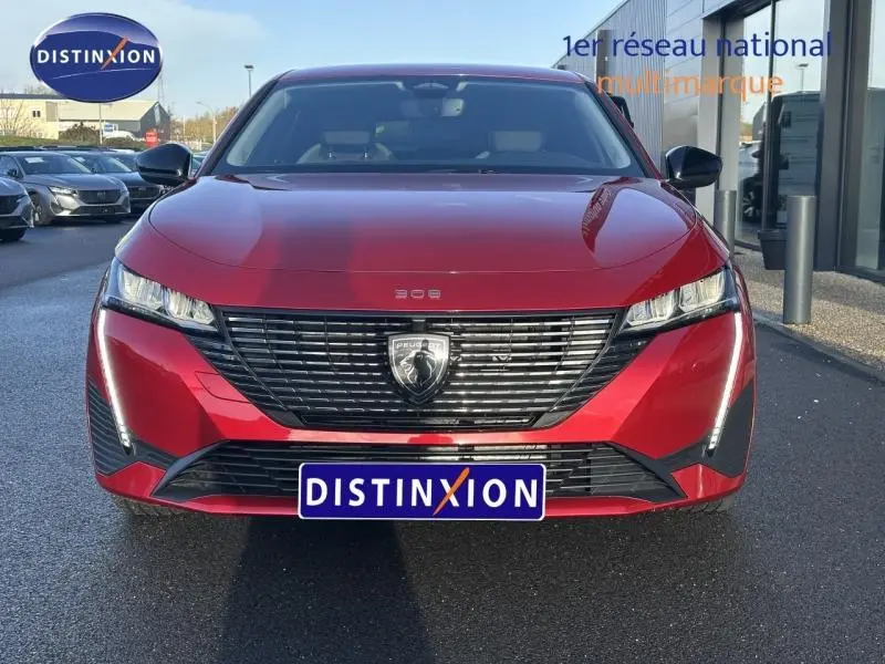 Vue frontale d'une Peugeot 308 SW 2024 en Rouge Elixir avec calandre noire et feux LED distinctifs.