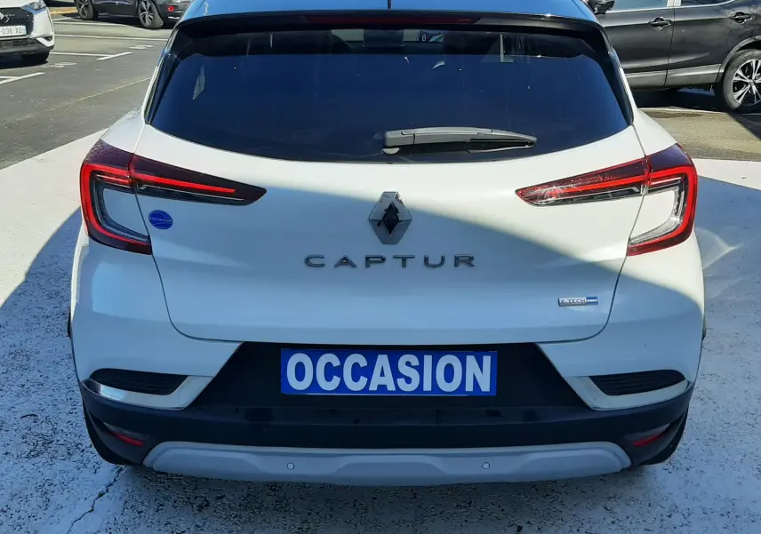 Vue arrière d'un Renault Captur blanc nacré avec toit noir, badge E-Tech visible et plaque "OCCASION".