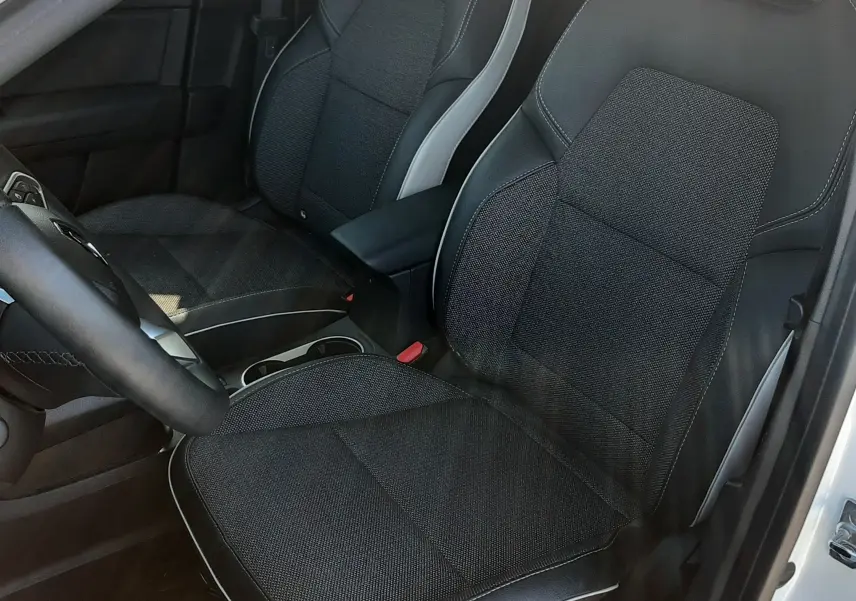 Vue intérieure côté conducteur du Renault Captur E-TECH 145ch Intens 2022, sièges tissu noir avec surpiqûres blanches.