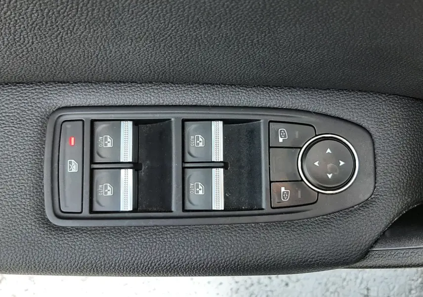 Panneau de commandes des vitres électriques et rétroviseurs sur la portière côté gauche d’un Renault Captur blanc nacré.