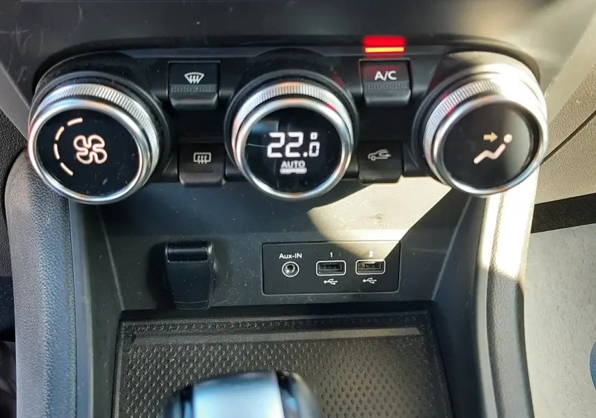 Gros plan sur la console centrale du Renault Captur E-Tech 145ch Intens 2022, montrant les commandes de climatisation et ports USB.