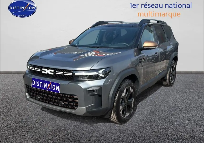 Vue 3/4 avant d’un Dacia Bigster gris schiste avec rétroviseurs bronze et jantes noires sur fond neutre.