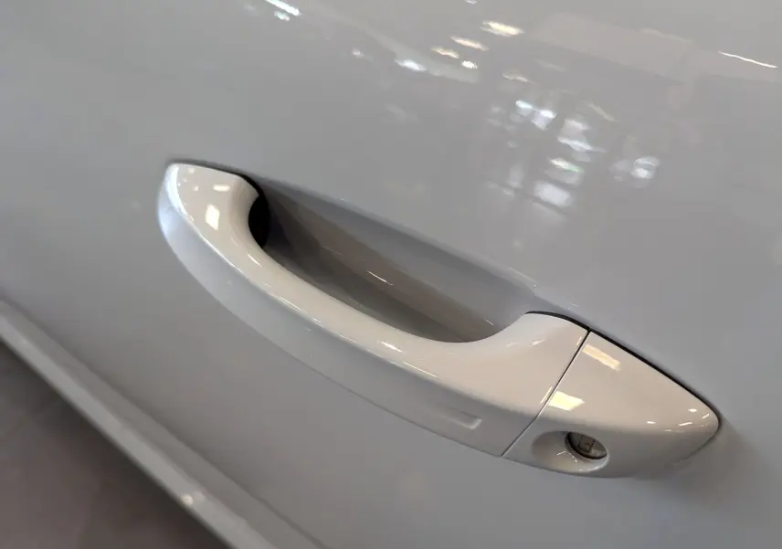 Poignée de porte blanche Okénite en gros plan sur une Peugeot 308 BlueHDi 130 CH EAT8 GT 2025.