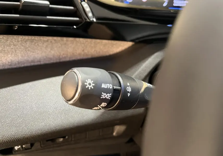 Gros plan sur la commande d'éclairage à gauche du volant du Peugeot 308 SW gris clair Metal Artense 2024.