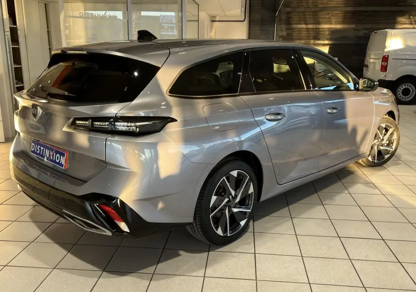 Peugeot 308 SW gris clair Metal Artense vue 3/4 arrière droit, avec jantes alliage et feux arrière LED distinctifs.