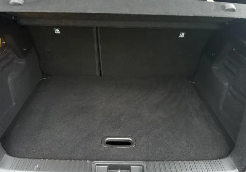 Vue intérieure du coffre spacieux et plat du Renault Captur 2025, revêtement noir uniforme sans chargement visible.