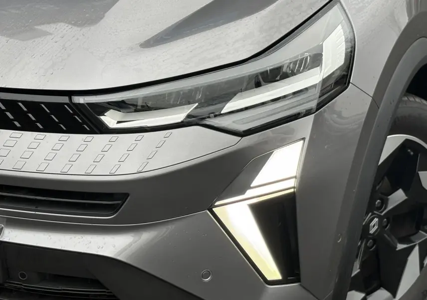 Gros plan sur l'avant droit du Renault Captur gris Cassiopée, mettant en valeur les phares LED et la jante alu noire diamantée.