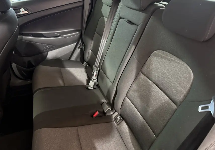 Vue intérieure côté droit sur la banquette arrière noire du Hyundai Tucson 2019, avec ceinture de sécurité visible.