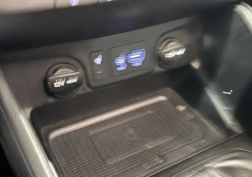 Gros plan sur la console centrale noire du Hyundai Tucson 2019, montrant prises 12V et commandes éclairées.