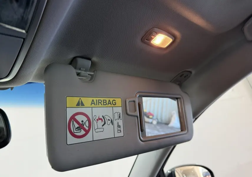 Détail intérieur du pare-soleil côté conducteur avec miroir et avertissement airbag dans un Hyundai Tucson noir 2019.