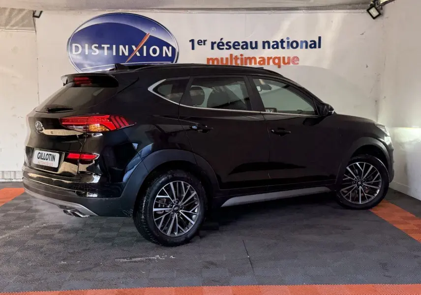 Vue 3/4 arrière droite d’un Hyundai Tucson noir 2019 avec jantes alliage et feux arrière LED visibles.