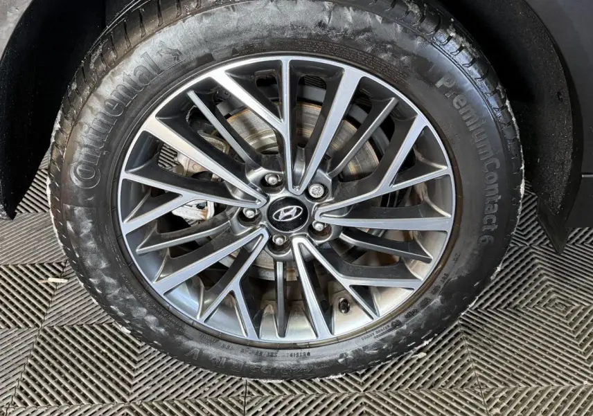 Gros plan sur la jante alliage grise et pneu Continental du Hyundai Tucson noir, vue latérale côté droit.
