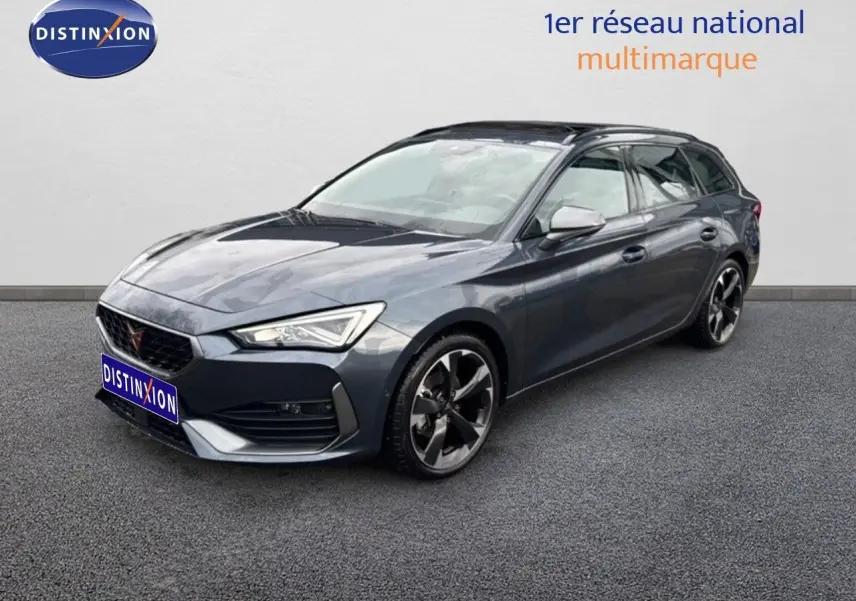 Vue 3/4 avant d'une CUPRA LEON ST gris magnétique avec jantes bi-ton et calandre distinctive.