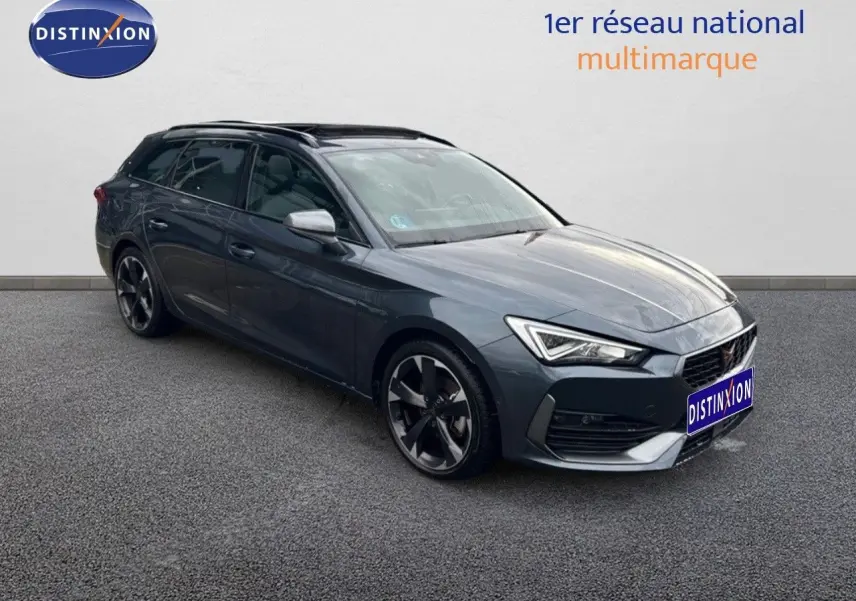 Vue 3/4 avant droite d'une CUPRA LEON ST gris magnétique avec jantes bi-ton et calandre distinctive.