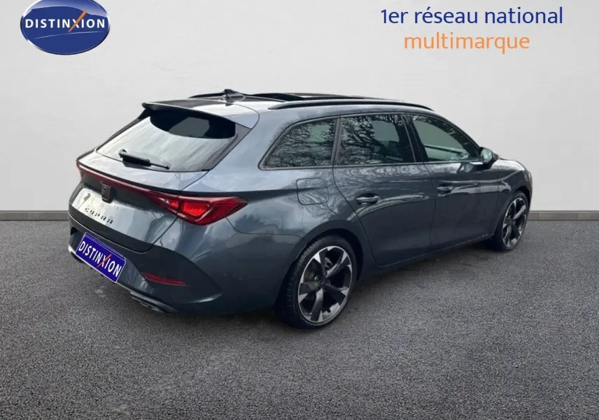 Vue 3/4 arrière droite d'une CUPRA LEON ST gris magnétique avec jantes bi-ton et feux arrière LED allumés.