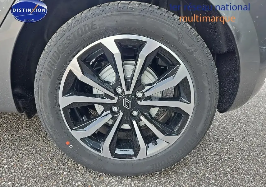 Gros plan sur la jante alu bicolore et pneu Bridgestone d'une Renault Clio V gris schiste, roue avant droite visible.