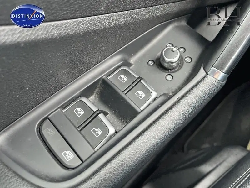 Gros plan sur les commandes de lève-vitres et réglage des rétroviseurs côté conducteur de l'Audi Q2 2018 finition Design blanc.