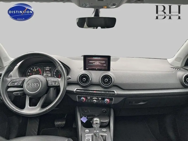 Intérieur noir de l'Audi Q2 2018, vue frontale sur le tableau de bord avec écran central et volant multifonction.