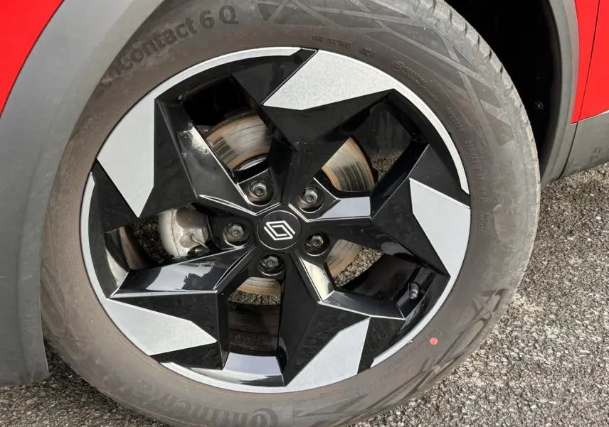 Gros plan sur la jante alu 18 pouces diamantée noire du côté gauche d’un Renault Captur Rouge Flamme / Noir.