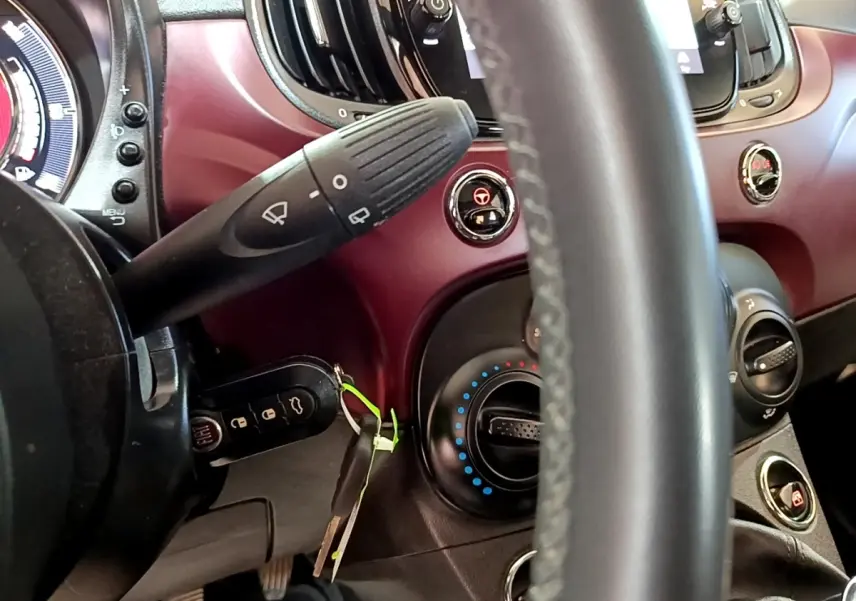 Vue intérieure rapprochée du tableau de bord rouge et du volant cuir de la Fiat 500 1.0 70ch BSG Star 2021.