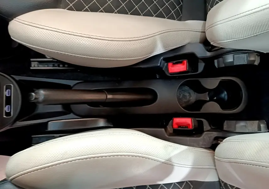 Vue plongeante sur la console centrale noire et les sièges beige clair de la FIAT 500 rouge, version 1.0 70ch BSG Star.