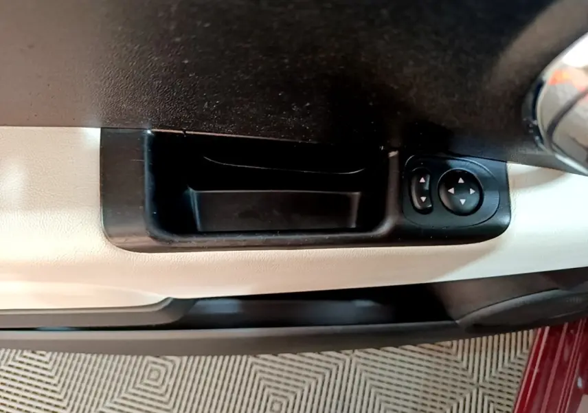 Détail de la commande des rétroviseurs sur la porte côté conducteur d'une FIAT 500 rouge.