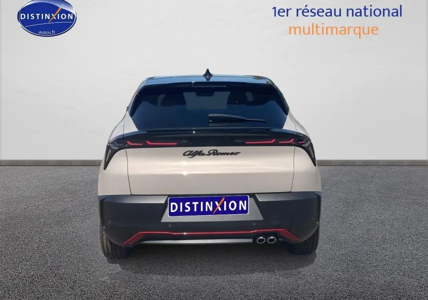 Vue arrière d'une Alfa Romeo Junior 1.2 hybride ivoire et noir avec feux arrière LED et double sortie d'échappement.