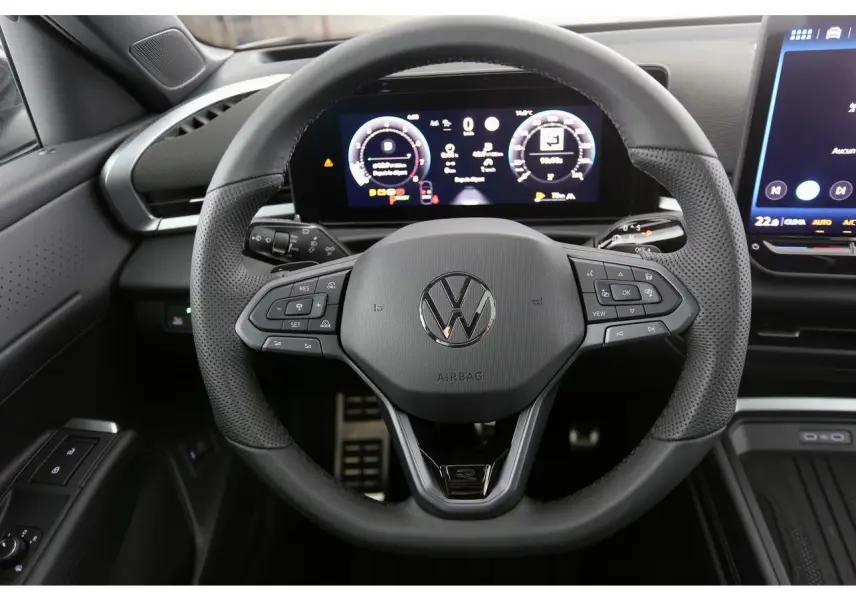 Vue rapprochée du volant sport en cuir noir du Volkswagen T-Roc 2026 avec tableau de bord numérique et commandes intégrées.