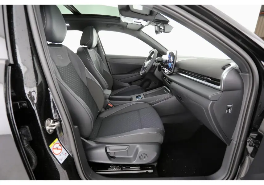 Vue intérieure côté conducteur du Volkswagen T-Roc 2026 avec sièges sport noirs et tableau de bord moderne.