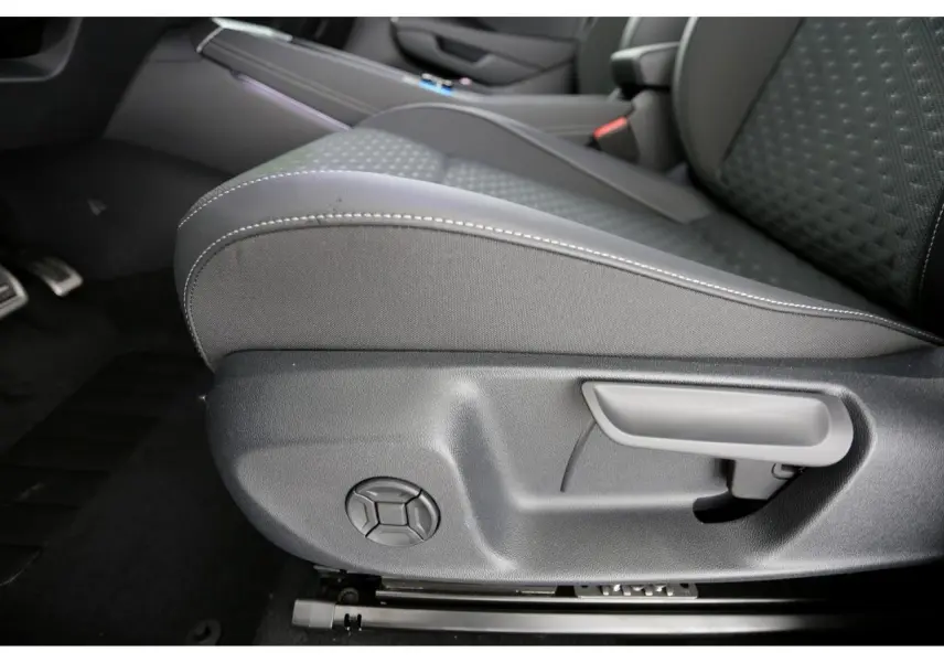 Gros plan sur le côté gauche du siège avant tissu gris avec coutures blanches du Volkswagen T-Roc 2026.