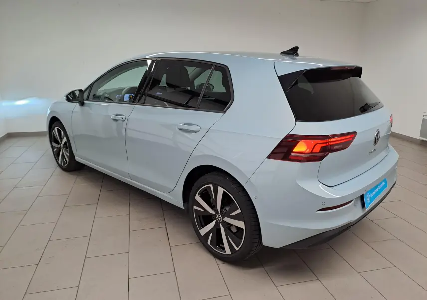 Vue 3/4 arrière droite d'une Volkswagen Golf 1.5 eTSI 2025 en Bleu Glacier avec jantes alliage 18'' Catania.