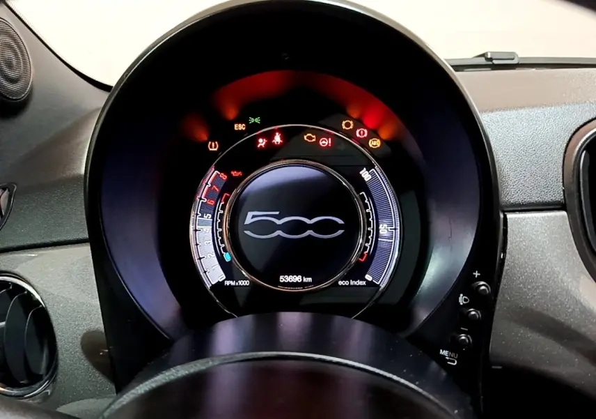 Vue rapprochée du tableau de bord circulaire de la Fiat 500 gris foncé, affichant les voyants d'alerte allumés.