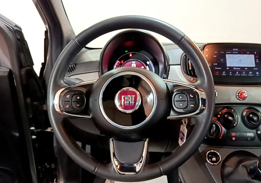 Vue centrée sur le volant cuir multifonctions noir du tableau de bord de la Fiat 500 gris foncé 2021.