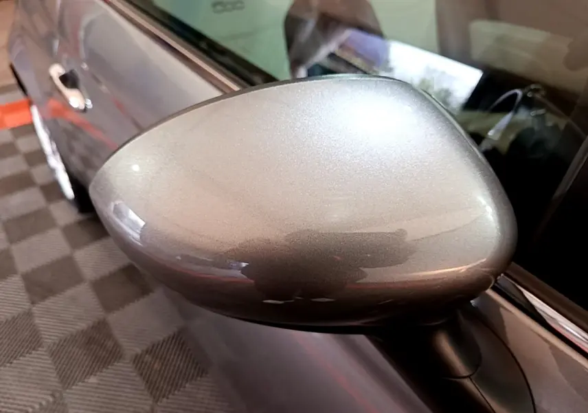 Rétroviseur gris foncé en gros plan côté gauche d’une FIAT 500 Hybrid 2021, avec portière et intérieur partiellement visibles.