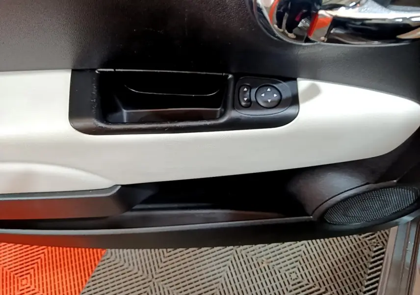 Vue rapprochée de la porte côté gauche de la Fiat 500 Hybrid 2021, avec panneau bicolore noir et beige et commandes de vitres.