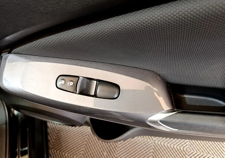 Gros plan sur la commande de verrouillage des portes côté conducteur du Nissan Juke noir 2023.