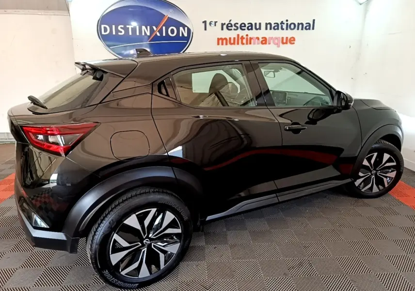 Vue 3/4 arrière droite d'un Nissan Juke noir 2023 avec jantes noires et détails de carrosserie lisse et moderne.