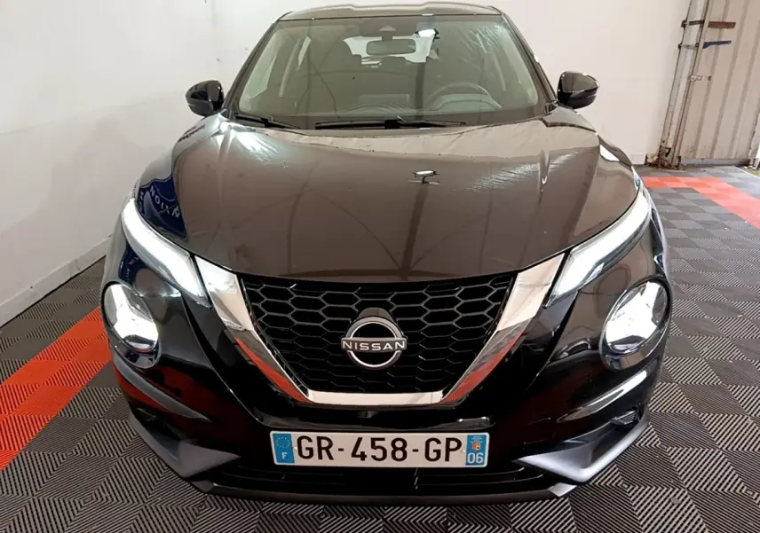 Vue avant d'un Nissan Juke noir 2023 avec calandre en nid d'abeille et phares LED ellipsoïdaux visibles.