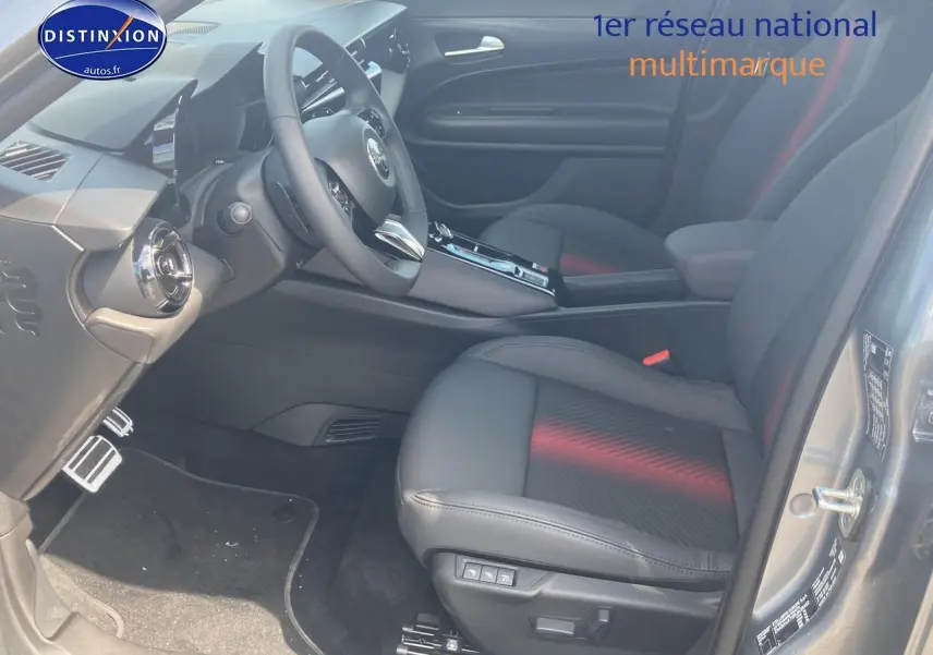Intérieur avant droit de l'Alfa Romeo Junior 1.2 hybride gris, sièges cuir noirs avec surpiqûres rouges et tableau de bord moderne.