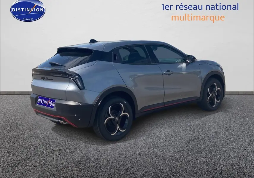 Vue 3/4 arrière droite d'une Alfa Romeo Junior gris métallisé avec jantes en alliage et hayon électrique.