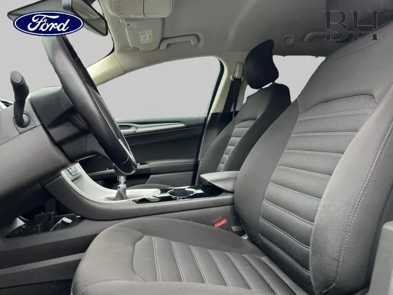 Intérieur de la Ford Mondeo SW 2016 vu côté conducteur, sièges tissu gris et console centrale avec levier de vitesses.