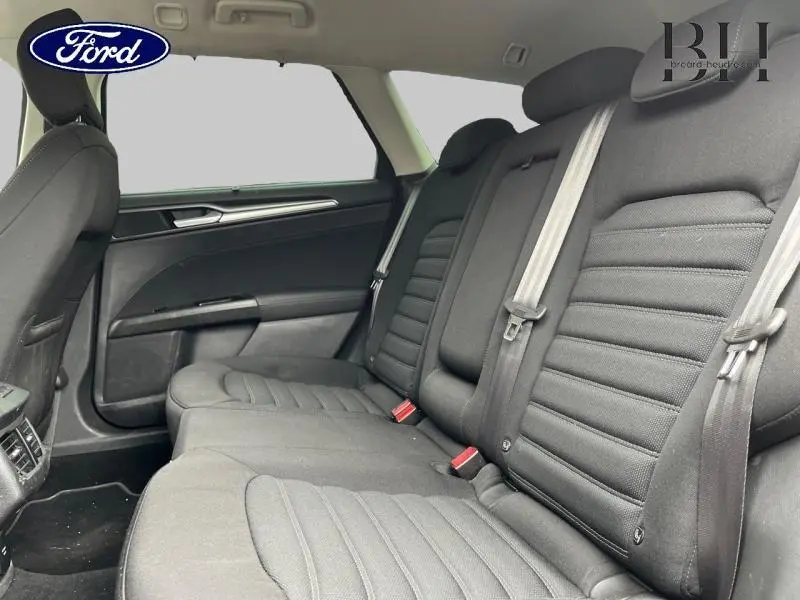 Vue intérieure arrière droite des sièges noirs en tissu de la Ford Mondeo SW 2016, avec ceintures de sécurité visibles.