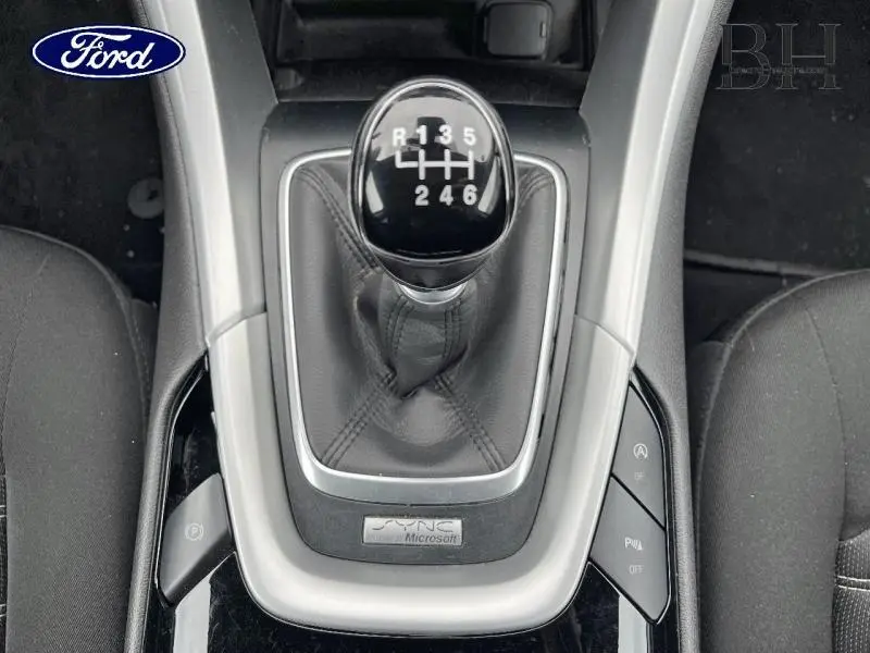 Gros plan sur le levier de vitesses manuel noir de la Ford Mondeo SW 2.0 TDCi avec console centrale grise et sièges noirs.