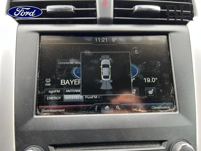 Écran tactile central de la Ford Mondeo SW 2.0 TDCi 2016 affichant l'aide au stationnement et la température intérieure.